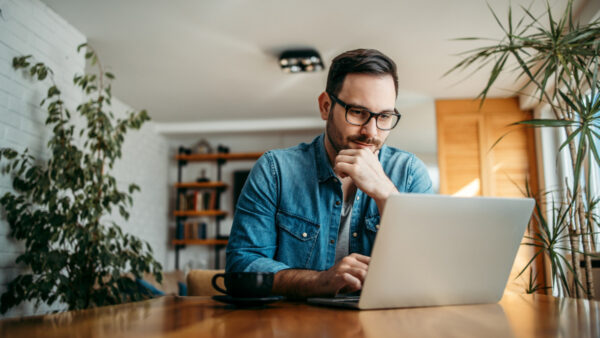 Man looking thoughtful with laptop