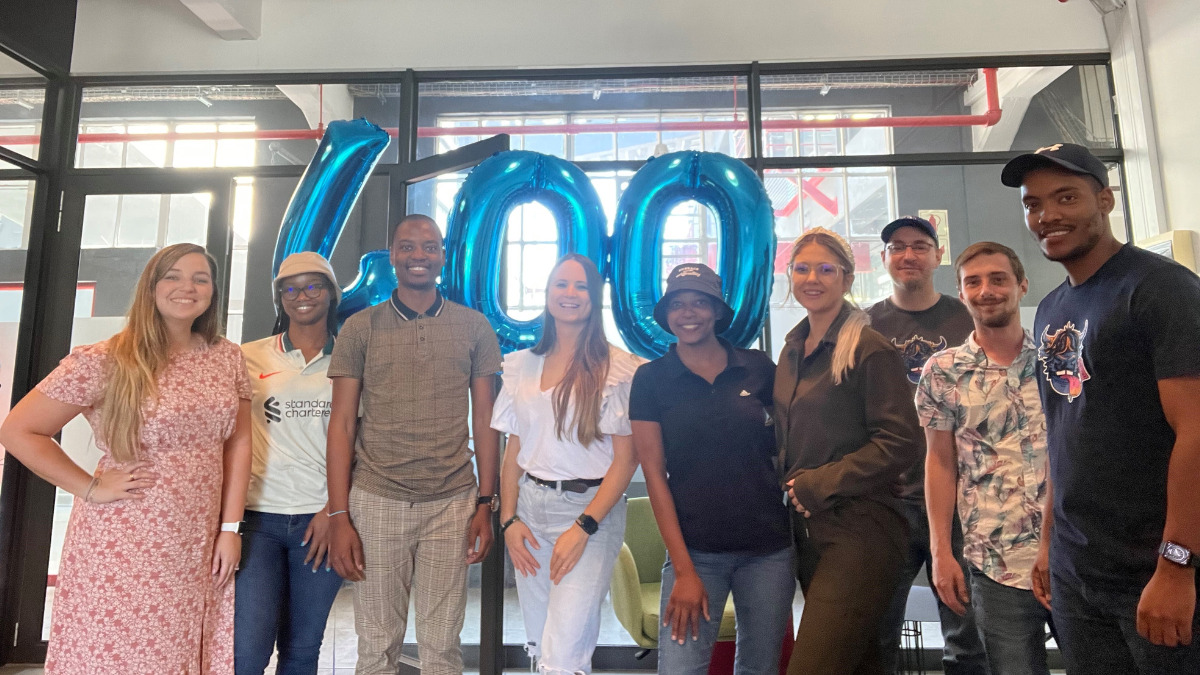 Photo of South Africa office team, in front of a 400 foil balloon