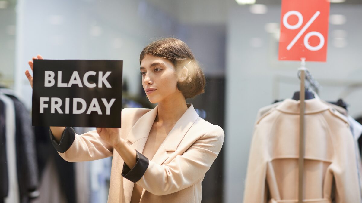 Person shopping on a couch looking at Black Friday 2024 deals.