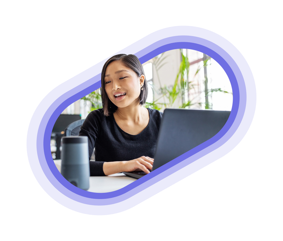 A person sitting in an office space on their laptop