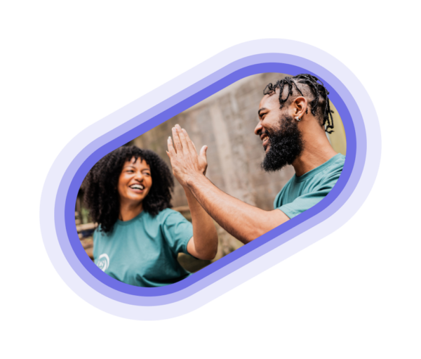 Two volunteers in blue shirts giving a high five