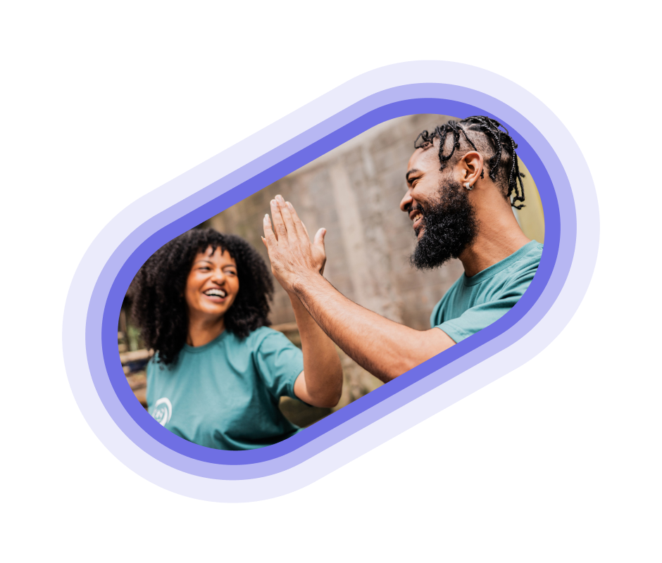 Two volunteers in blue shirts giving a high five