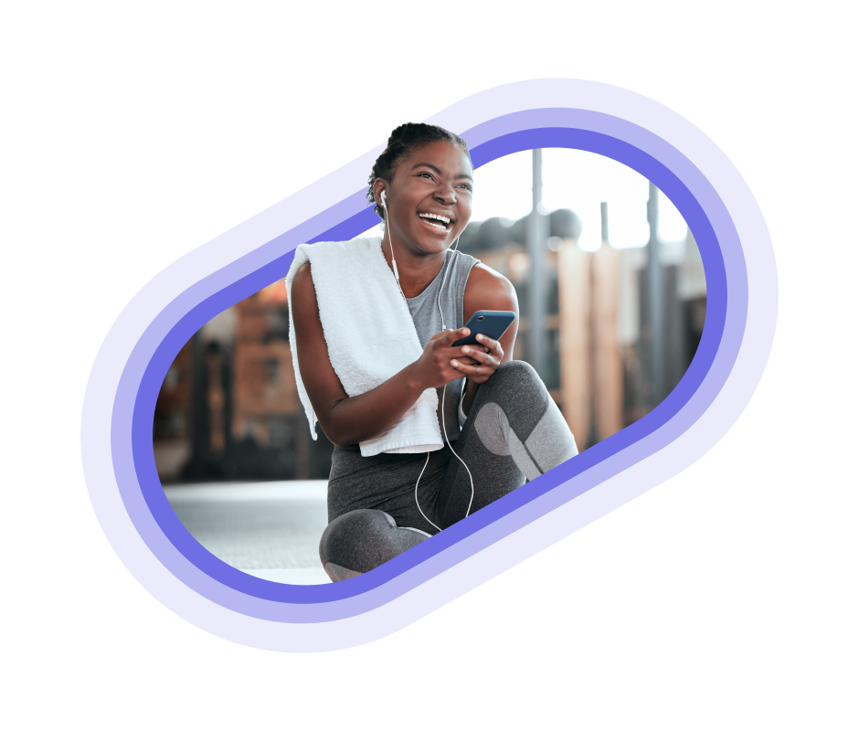 A person using their phone and smiling at the gym