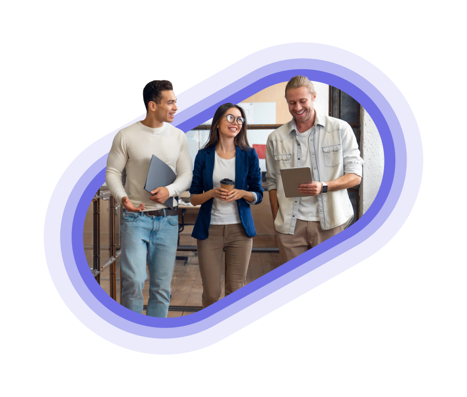 Three employees walking and smiling carrying different office objects