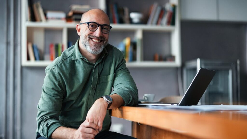 Professional Man Sitting at Desk in Modern Office Space stock photo