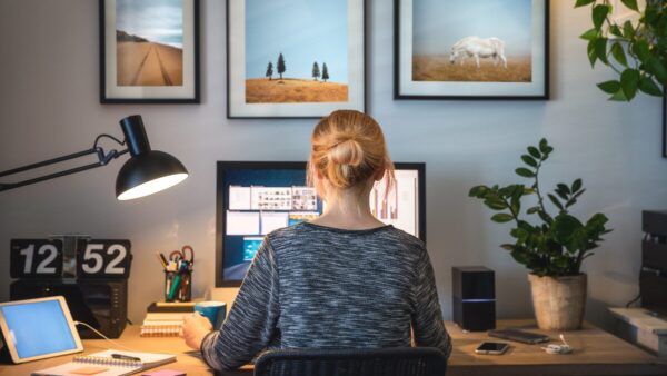 woman working on a report at her computer, facing away from camera