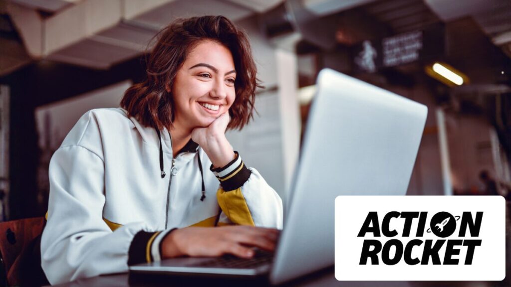 Happy woman smiling at laptop writing for email