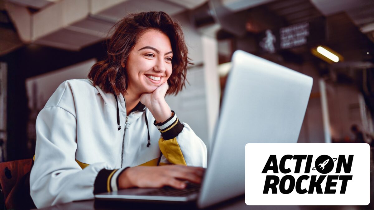 Happy woman smiling at laptop writing for email