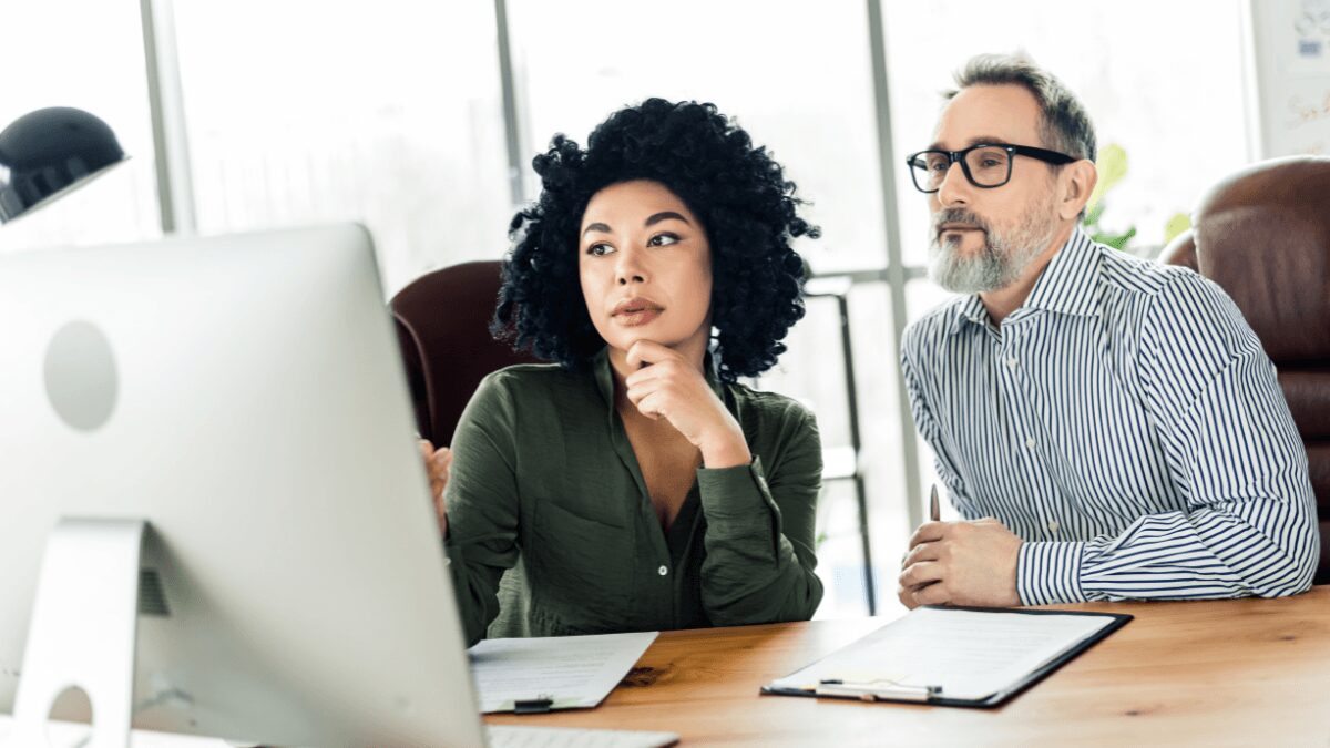 Two people thinking and looking at a display screen together