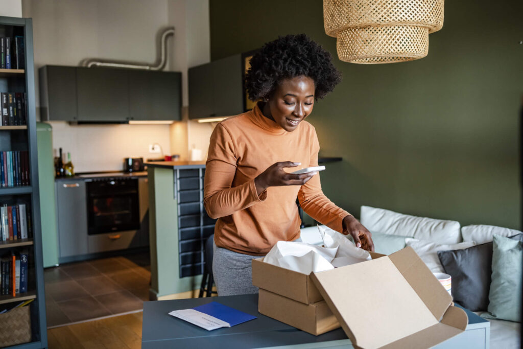 Young woman taking a photo of a subscription box stock photo