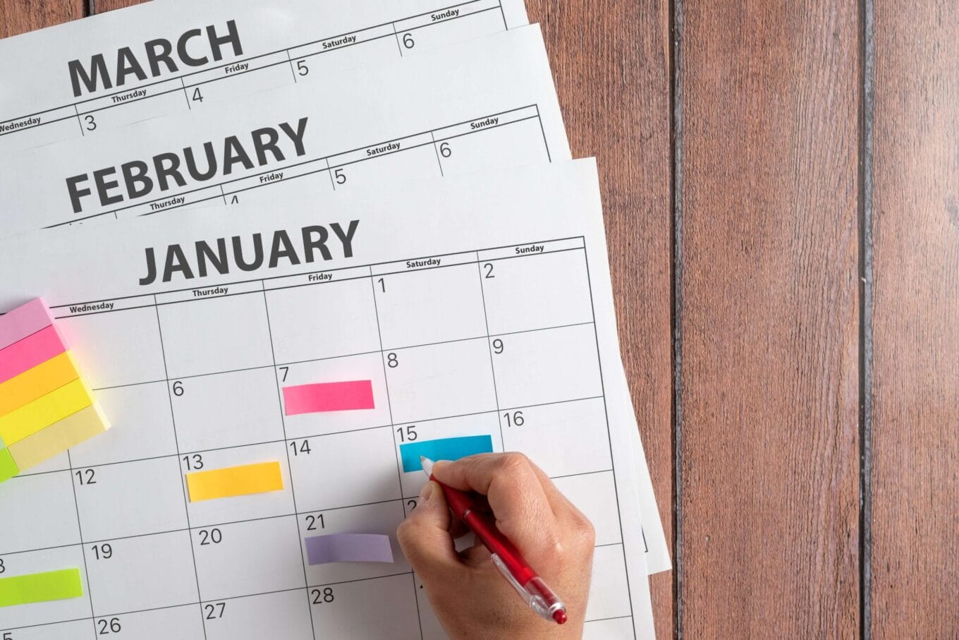 Someone writing in a monthly calendar 