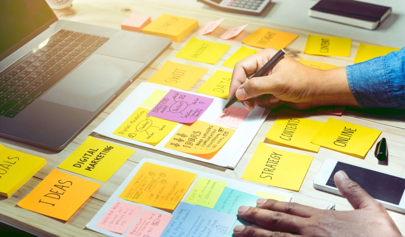 Person writing on post-it notes for planning their content calendar 