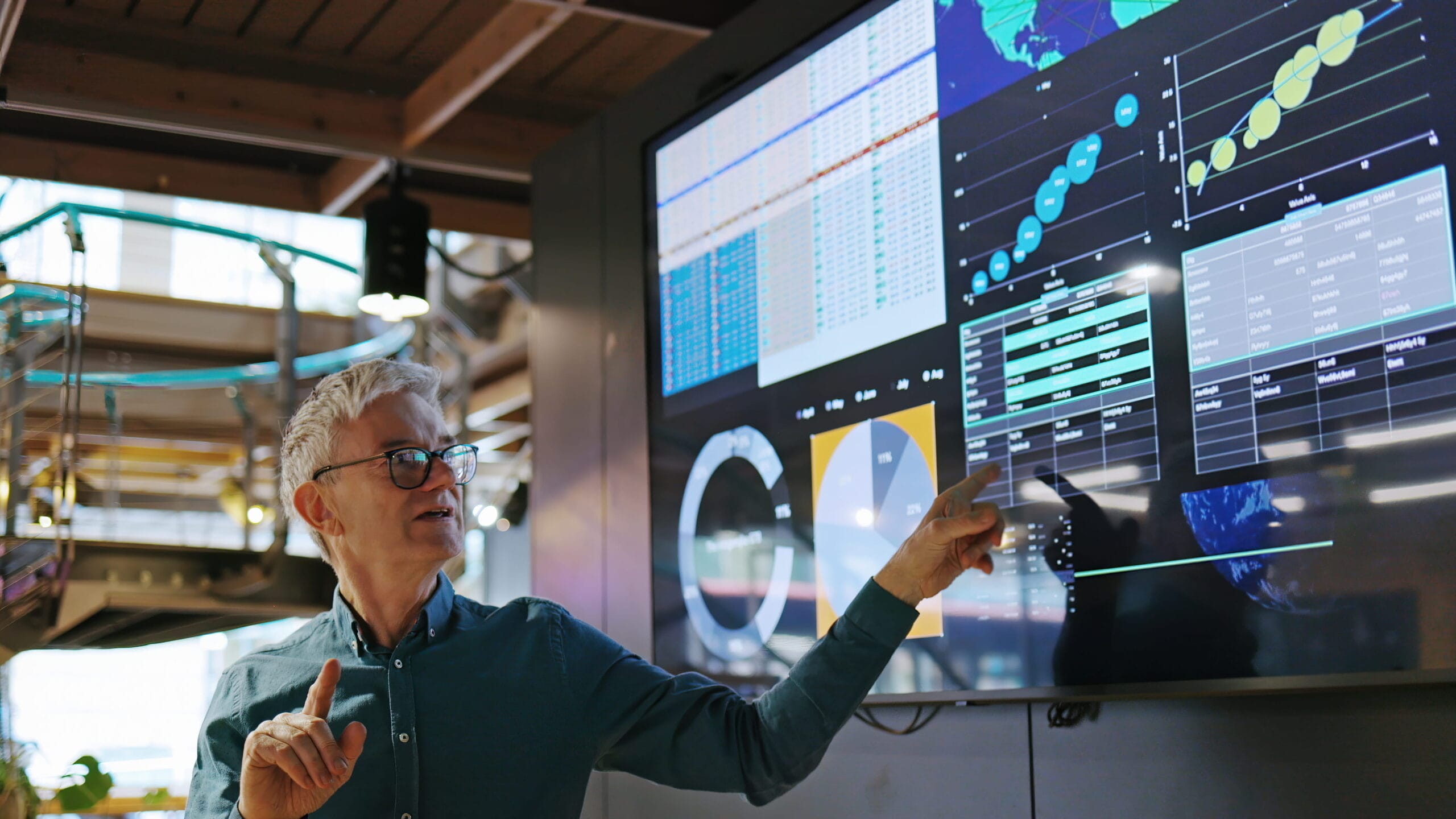 Man pointing to a display screen full of data