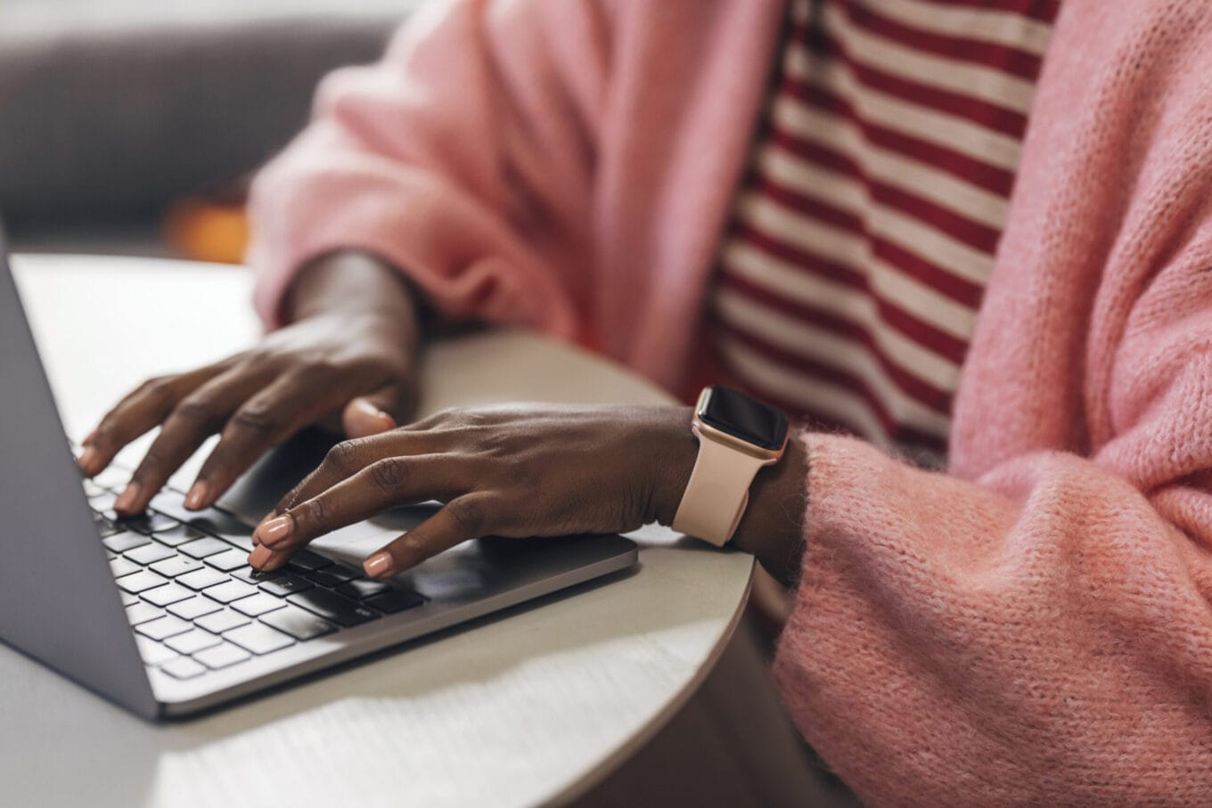 Close up shot of an anonymous woman typing on a laptop's keyboard