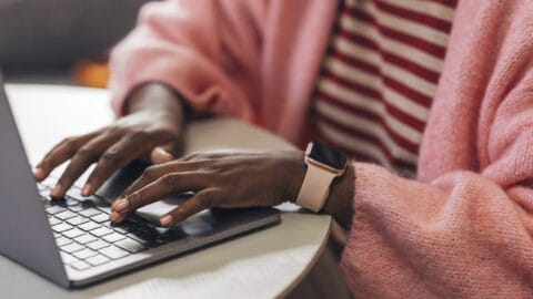 Close up shot of an anonymous woman typing on a laptop's keyboard