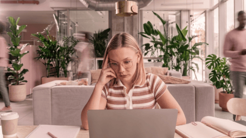 Woman in an office looking stressed while working on email marketing campaign