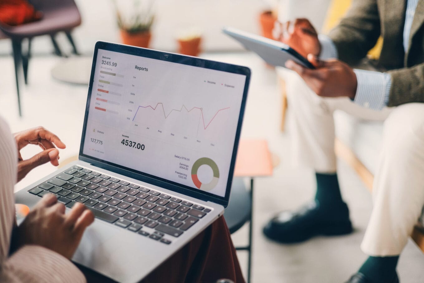 Business Team Analyzing Financial Data on Laptop with Digital Reports