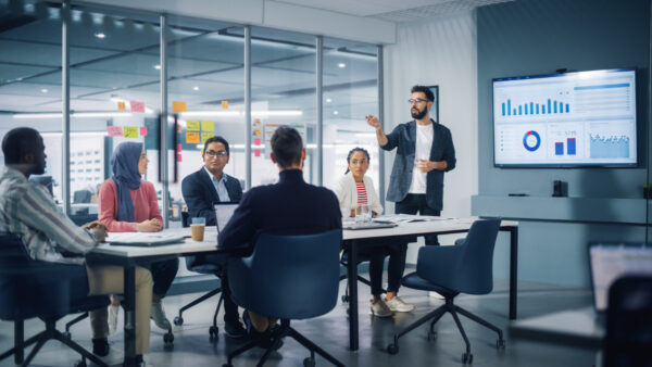 Office workers around a table talking about their martech stack