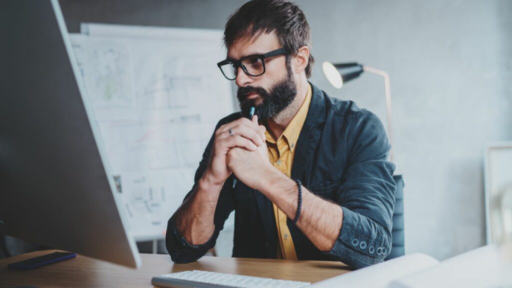 An attentive marketer creating email designs and impactful email marketing strategies on his laptop.