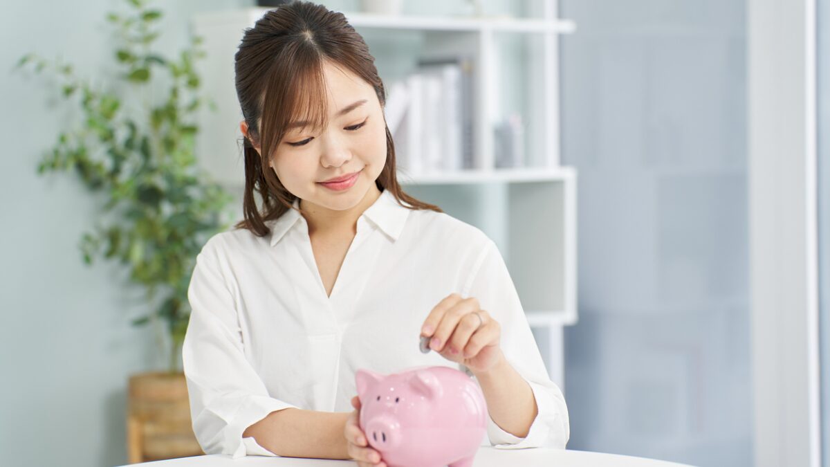 A marketer inserting coins into a piggy bank, representing successful revenue attribution